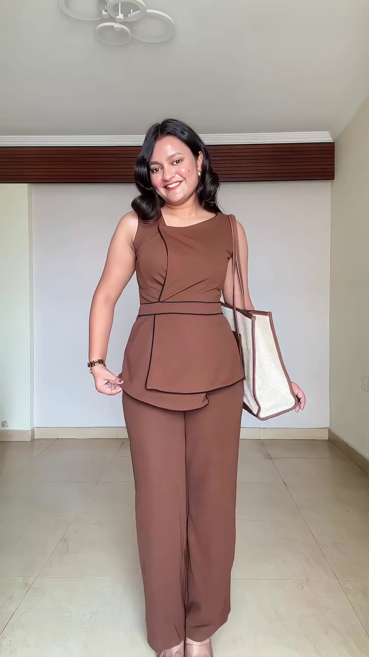 Chic Minimalism: Sleeveless Black Top with White Trim Paired with Trousers