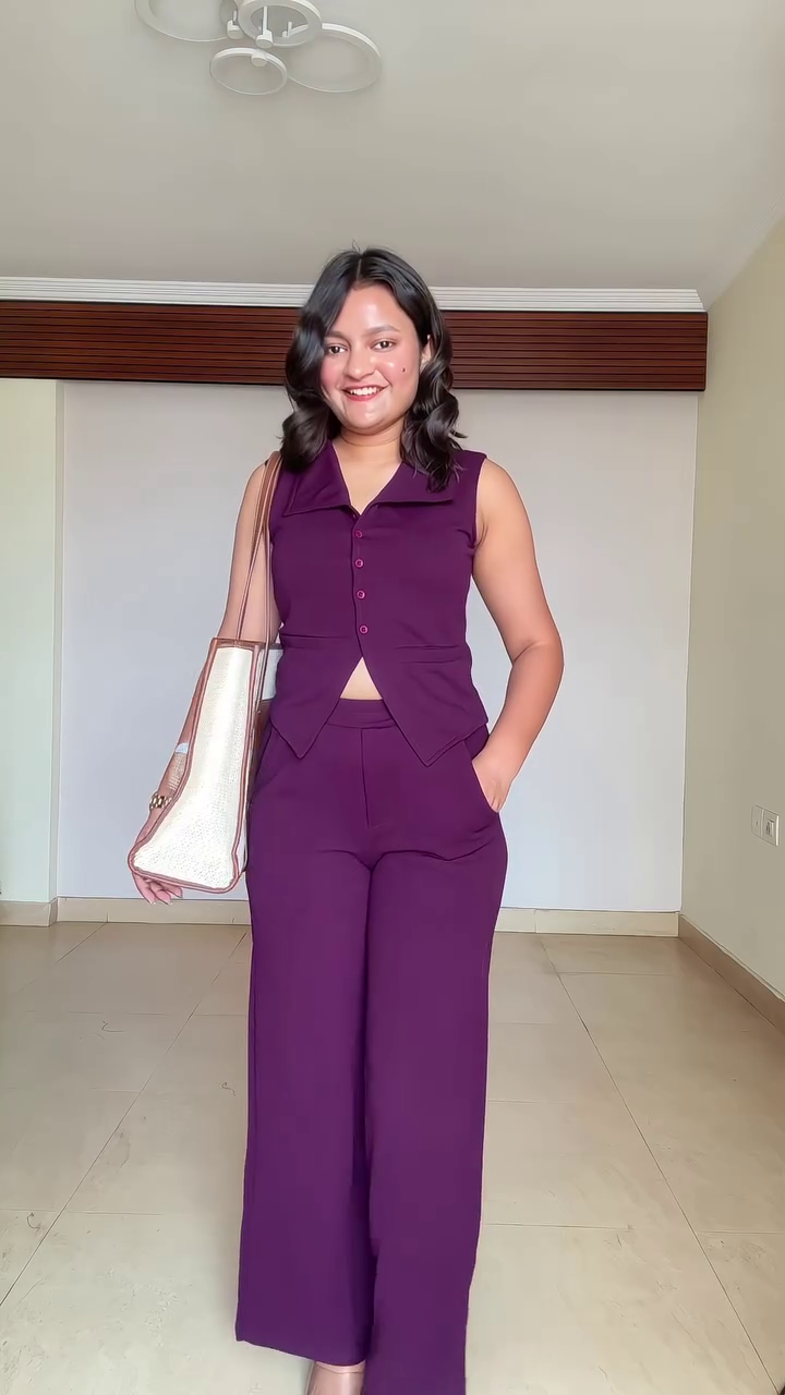 Chic Minimalism: Sleeveless Black Top with White Trim Paired with Trousers